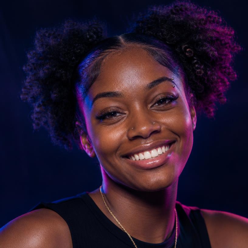 Young Black woman with afro puffs, nose stud and eyebrow piercing, smiling brightly